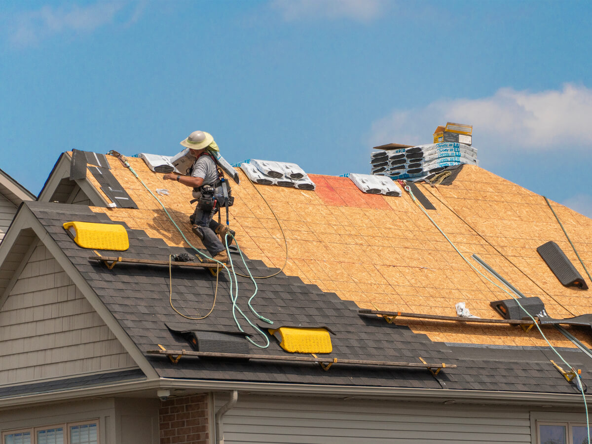 Roofer Carrying Shingles on Residential Roof in Frisco Texas
