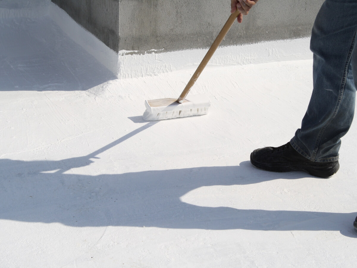 Roofer Applying Water Proof Coating To Commercial Building in Frisco Texas