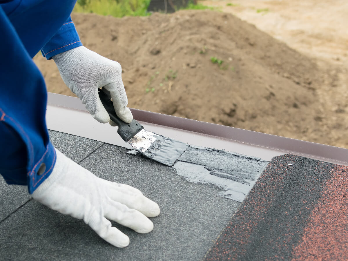 Roofer Applying Silicone Sealant to Roof Seams in Frisco Texas